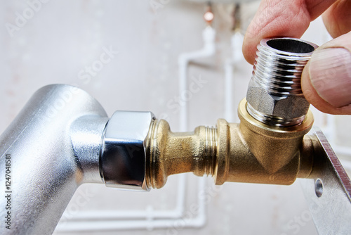 Cuadro en lienzo Plumber connects threaded reducer to brass fitting in plumbing system with visible pipes in background