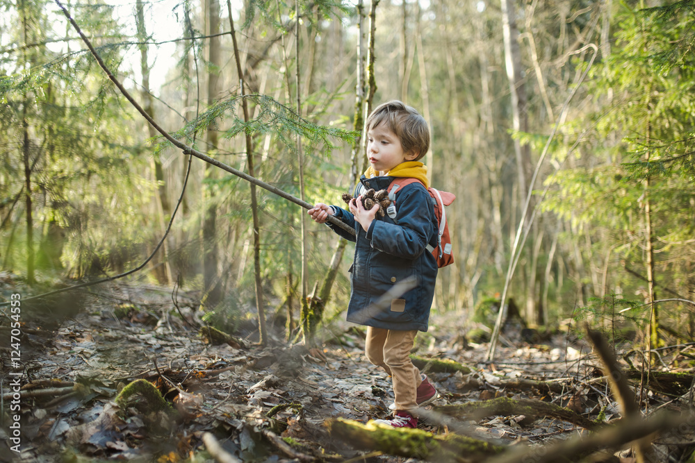Adorable little boy having fun during a hike in the woods on beautiful sunny spring day. Active family leisure with kids. Adorable little boy having fun during a hike in the woods on beautiful sunny spring day. Active family leisure with kids.