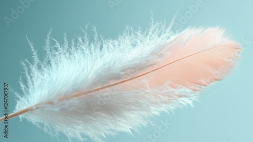 Soft white feather floating gracefully against a tranquil blue background in ...
