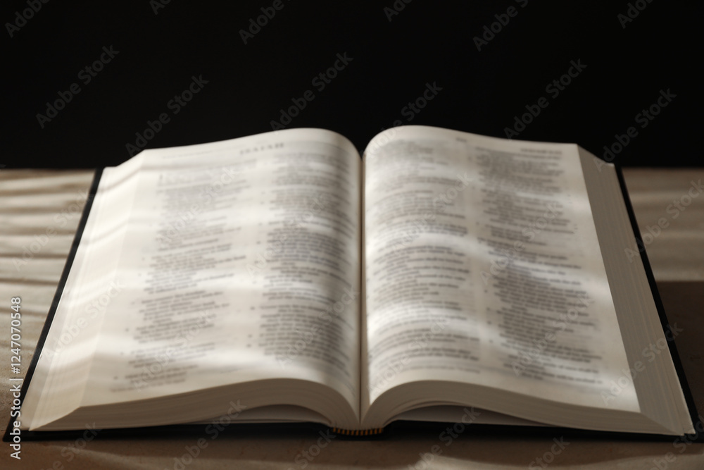 Open Holy Bible in English language on beige table, closeup Open Holy Bible in English language on beige table, closeup
