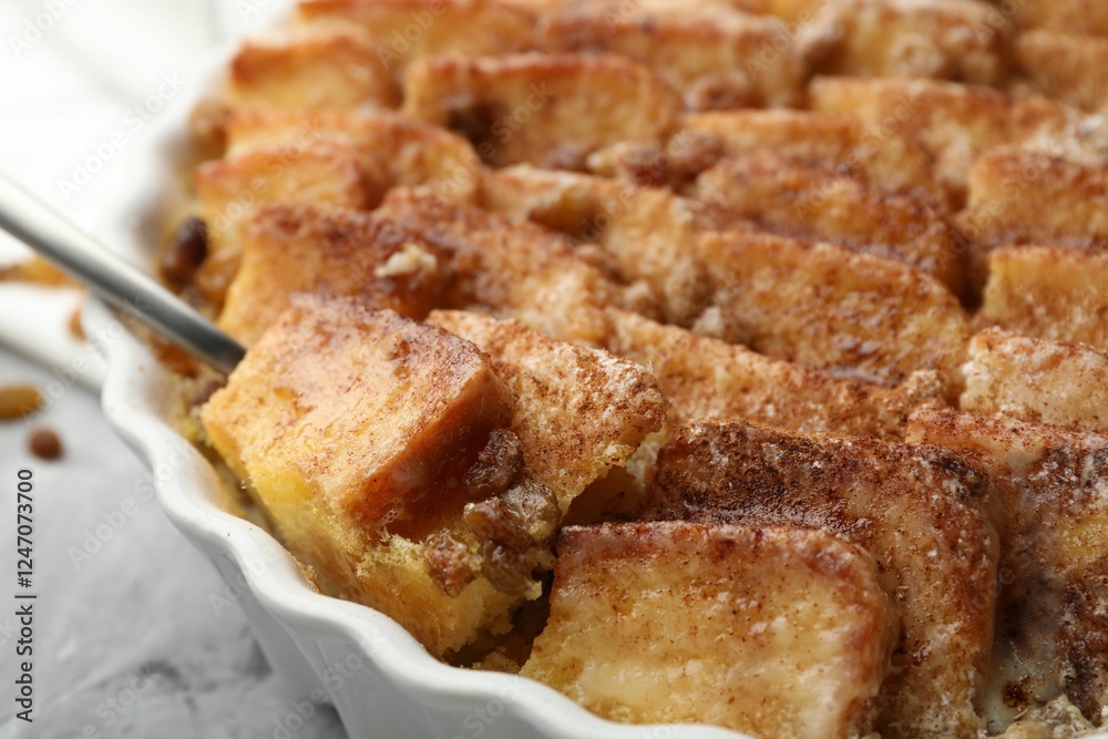 Delicious bread pudding with raisins and cinnamon on table, closeup Delicious bread pudding with raisins and cinnamon on table, closeup