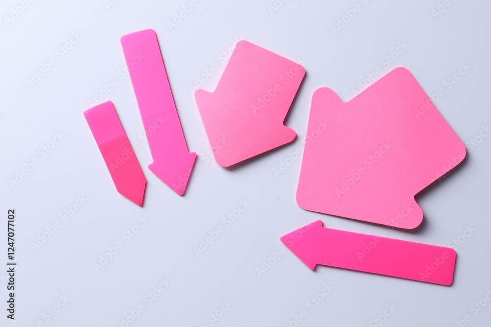 Pink paper arrows on white background, flat lay. Space for text Pink paper arrows on white background, flat lay. Space for text