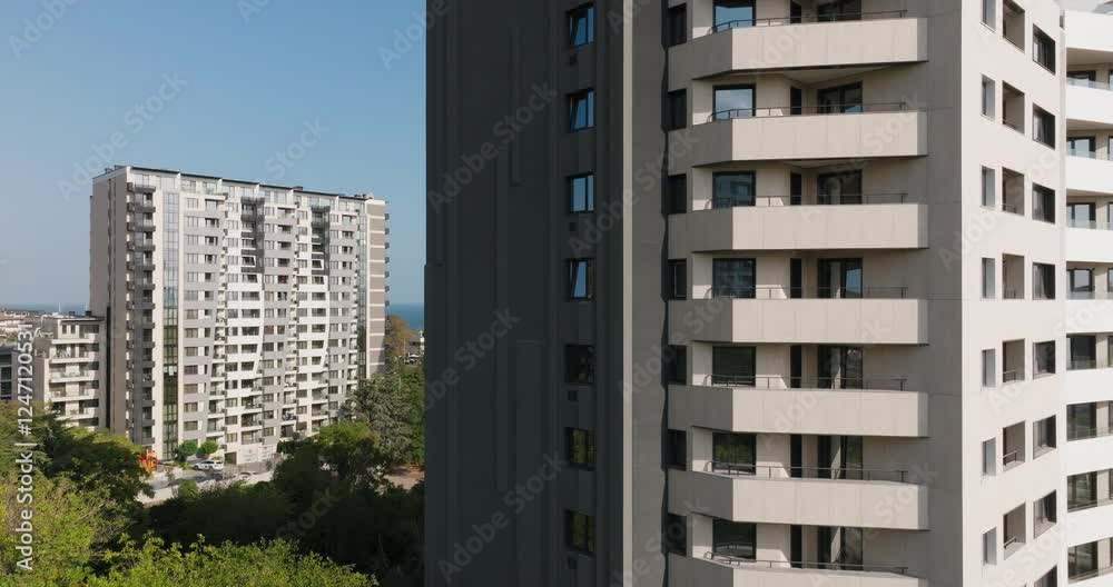 Contemporary apartment building featuring spacious terraces and sleek design aerial view. Ocean stretches in background, contrasting natural urban development in a growing metropolitan area. Contemporary apartment building featuring spacious terraces and sleek design aerial view. Ocean stretches in background, contrasting natural urban development in a growing metropolitan area.