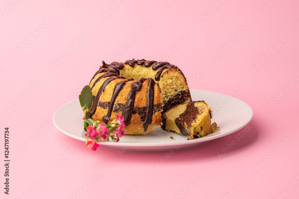 a small marble bundt cake with a piece cut and pink background