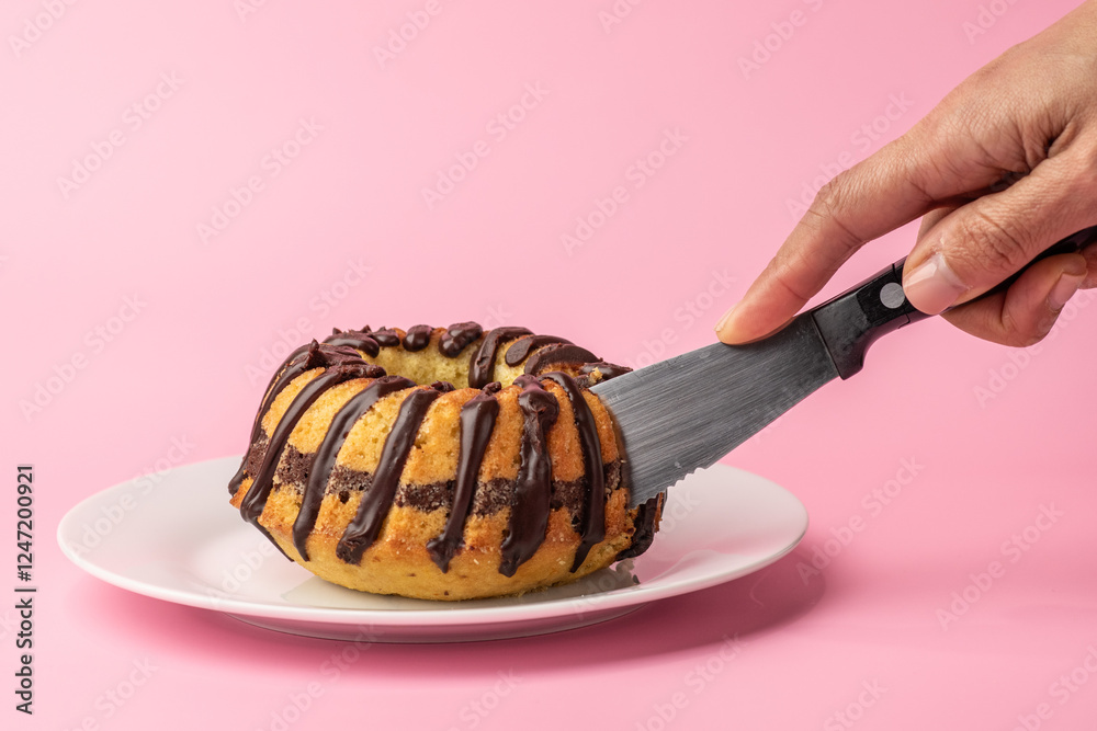 a small marble cake being cut with a knife