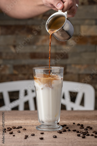 a hand pouring coffee into milk photo