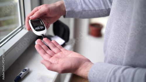 Close-up Of A Man's Hand Checking Blood Sugar Level With Glucometer