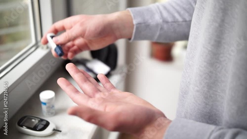 Close-up Of A Man's Hand Checking Blood Sugar Level With Glucometer