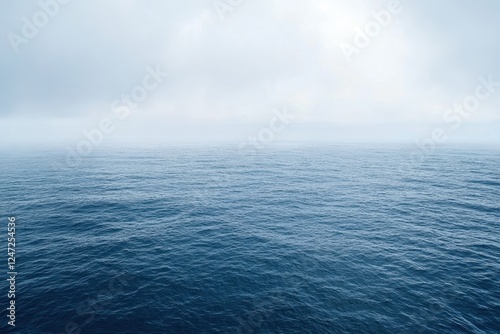 Calm ocean waves under cloudy sky at dawn near the coast with soft light reflecting on water photo