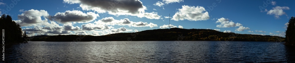 Expansive Nordic Lake Surrounded by Rolling Hills, Autumn Foliage, and a Dramatic Cloudscape in Serene Wilderness Expansive Nordic Lake Surrounded by Rolling Hills, Autumn Foliage, and a Dramatic Cloudscape in Serene Wilderness