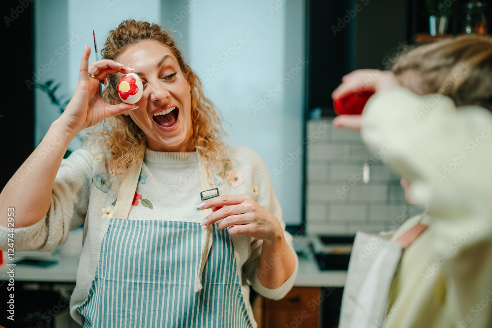 Fototapeta premium Woman showing painted easter egg and having fun with her daughter