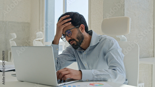 Anxious depressed Indian Arabian man stressed businessman working laptop in office distant job male tired muslim employer worried debt failure business trouble lost deadline crash bankruptcy overwork