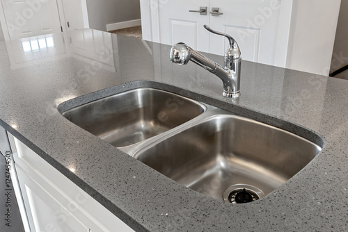 A stainless steel sink with a silver faucet sits on a countertop