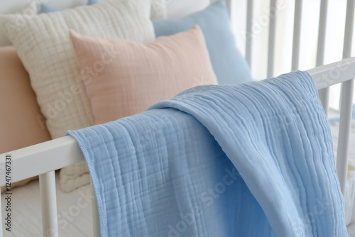 Close-up photo of stylish light pink and blue muslin bedding
