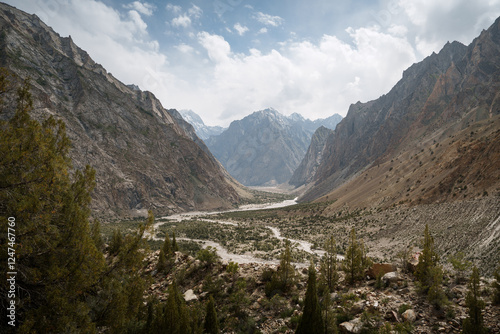 Majestic mountains and lush valley under a cloudy sky
