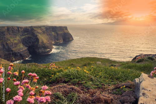 Spectacular scenery of Cliff of Moher, county Clare, Ireland. Warm sunny day. cloudy sky. Irish landscape. Irish flag colors in the sky photo