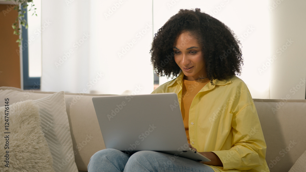 African American woman homeowner relaxing on couch with laptop device online chatting web surfing internet studying with computer at home ethnic girl businesswoman freelance business work e-learning African American woman homeowner relaxing on couch with laptop device online chatting web surfing internet studying with computer at home ethnic girl businesswoman freelance business work e-learning