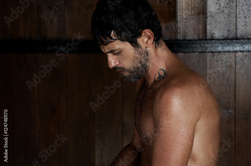 Side view of a handsome Man taking a shower in a backyard