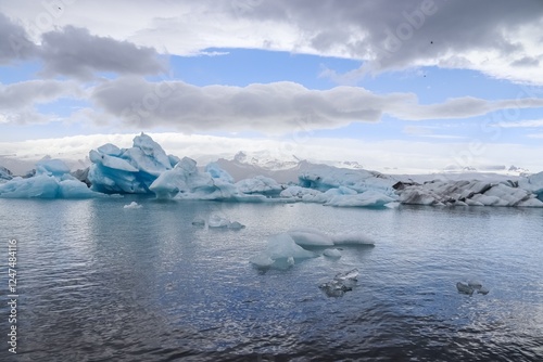Icebergs floating in jokulsarlon glacier lagoon in iceland under a cloudy sky photo