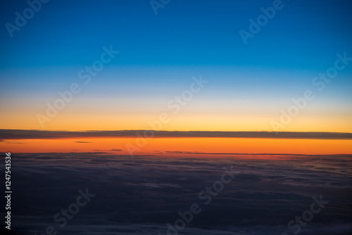 Minimalist horizon cloudscape sunrise. Dramatic sky, vibrant blue and orange colors. Aerial view. Just before morning sunrise.