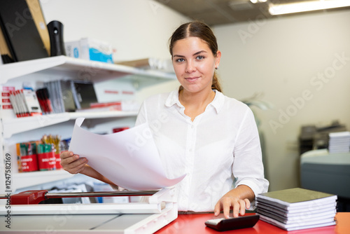 Worker in printing and press centar check the print quality photo