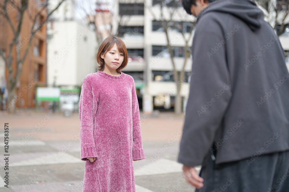 Fototapeta premium A Japanese man and woman in their 20s are playing kendama, a traditional New Year's game, in a deserted park in Sakae, Naka Ward, Nagoya City, Aichi Prefecture.