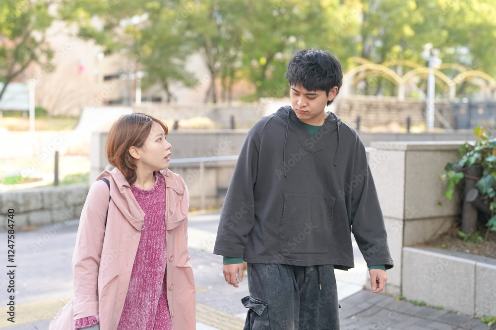 Fototapeta premium A Japanese man and woman in their 20s are walking on a public road in Sakae, Naka Ward, Nagoya City, Aichi Prefecture.