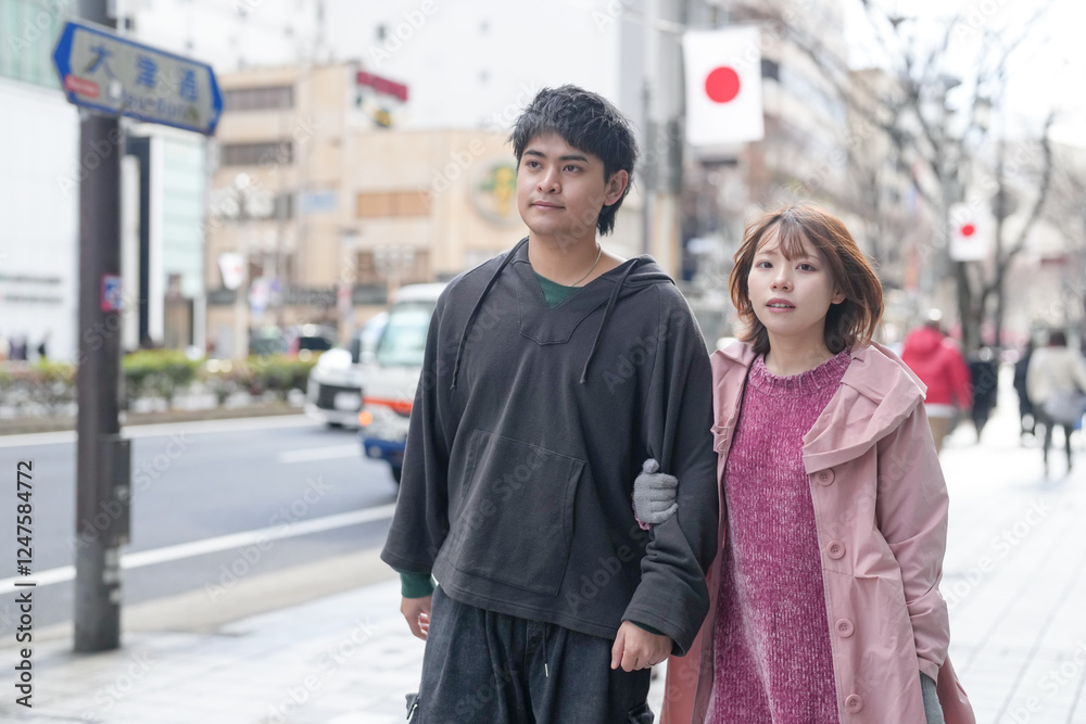 Fototapeta premium A Japanese man and woman in their 20s are walking on a public road in Sakae, Naka Ward, Nagoya City, Aichi Prefecture.