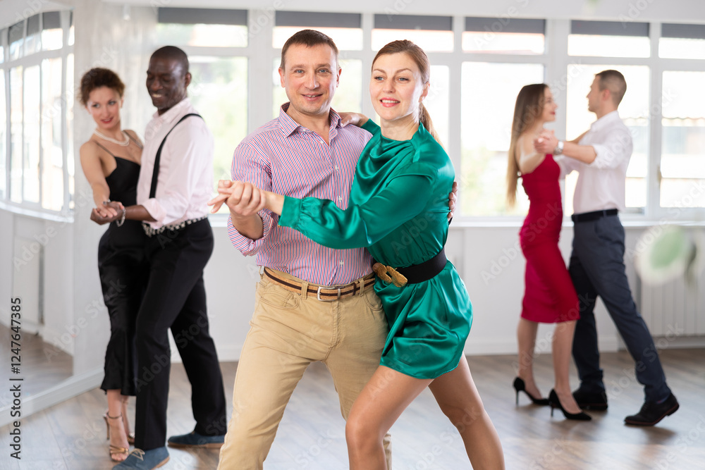 Fototapeta premium During rehearsal of reporting concert, man and woman participants of dance workshop perform figure waltz. Group training and rehearsal, preparation for competitions