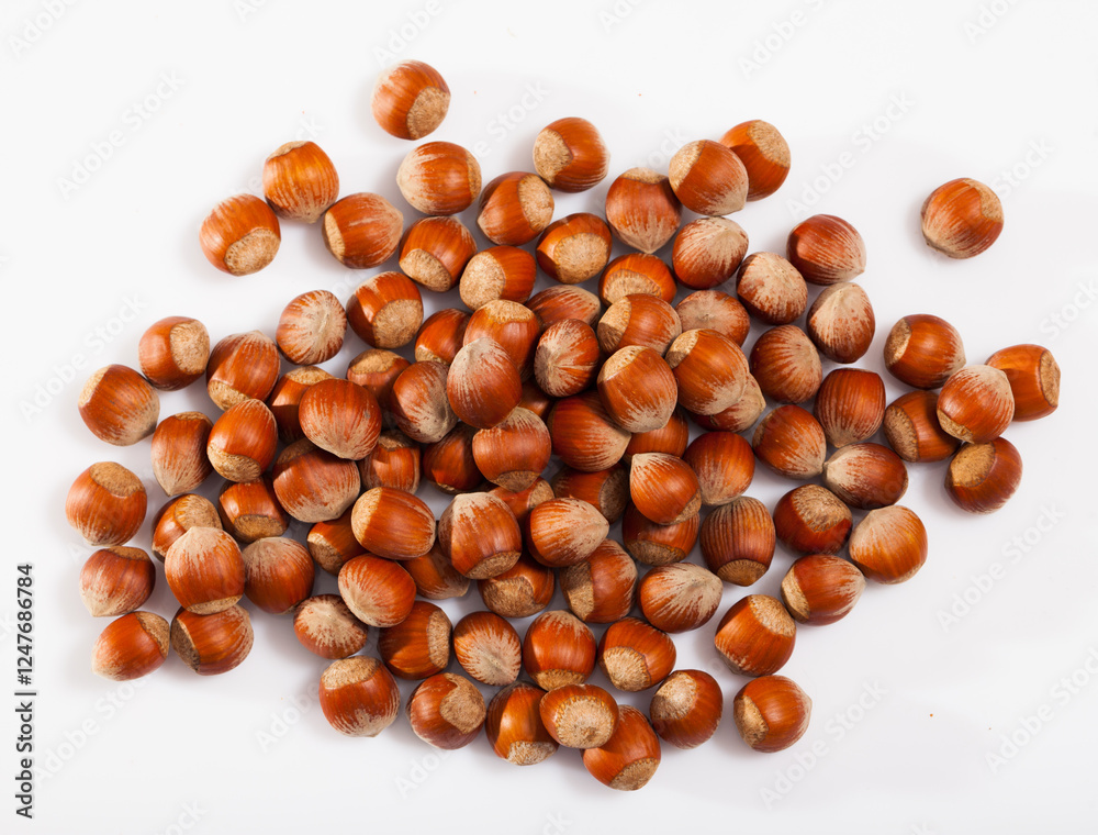Top view of pile of unshelled filbert nuts on white surface. Healthy snack Top view of pile of unshelled filbert nuts on white surface. Healthy snack
