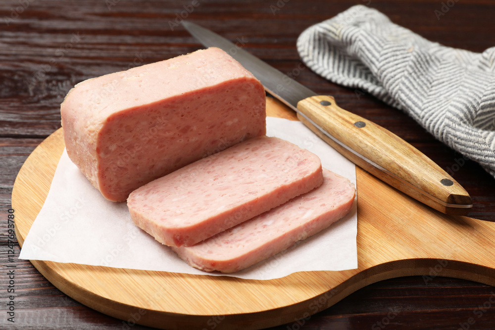 Tasty canned meat and knife on wooden table, closeup Tasty canned meat and knife on wooden table, closeup