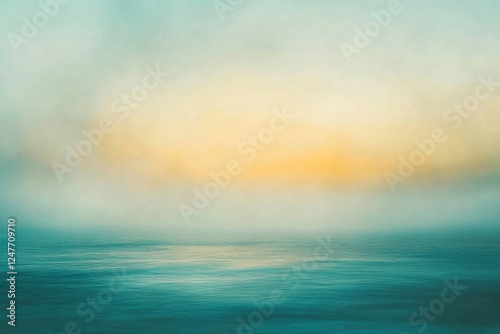 Serene sunrise over a calm ocean, with soft blue and gold hues blending in the horizon