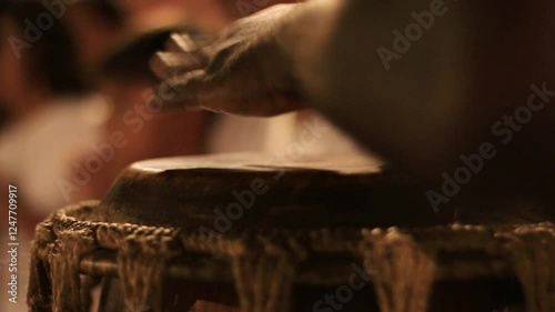 detail of a man playing the atabaque, a percussion instrument made of leather of African origin