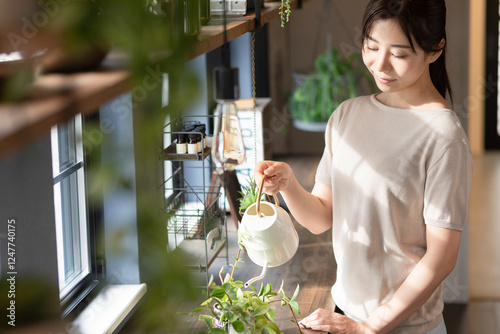 観葉植物に水やりをする女性 photo