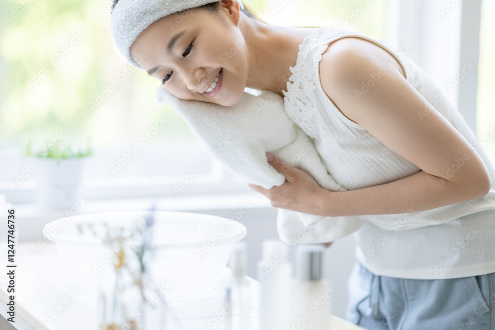 顔を拭く女性 顔を拭く女性