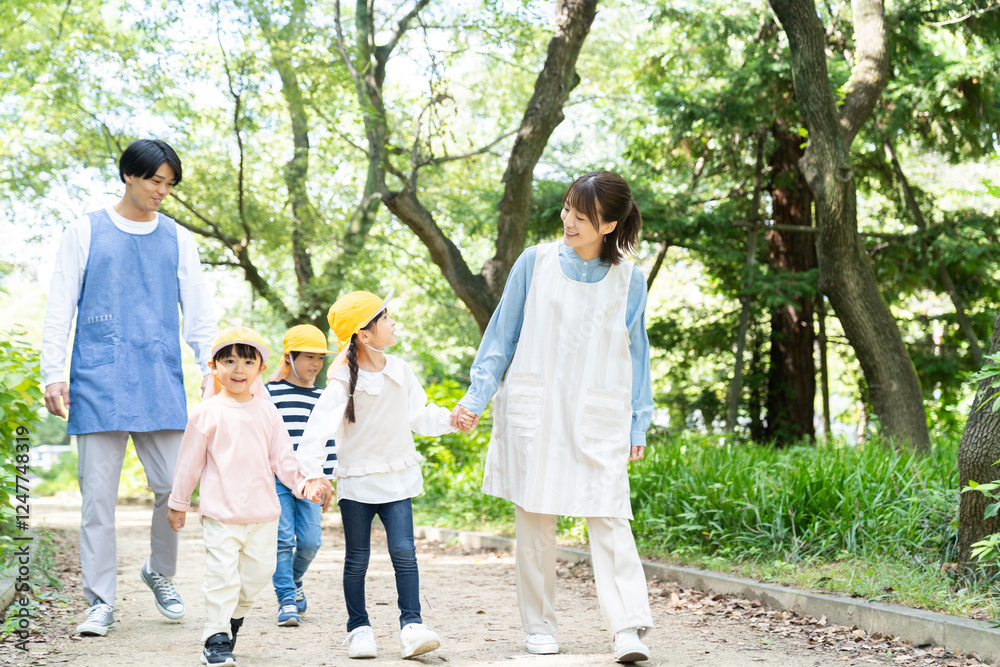 公園を散歩する保育士と園児