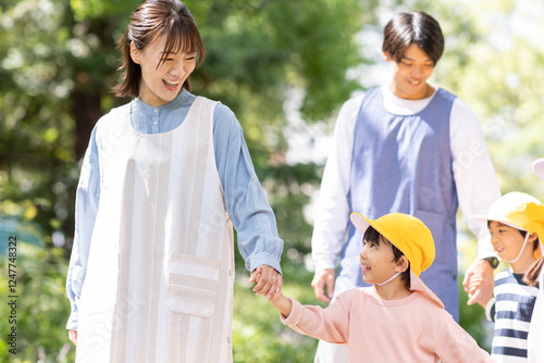 Fotografie 公園を散歩する保育士と園児