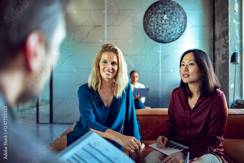 Professional businesswomen having a discussion in modern office lounge photo