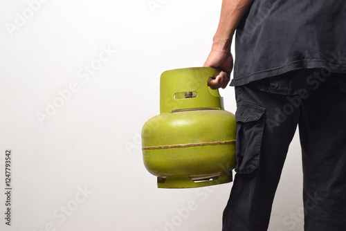 A man carrying a green 3 kg LPG gas cylinder, isolated on a white background photo