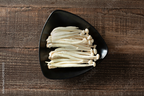 A top down view of a plate of large enoki mushrooms. photo