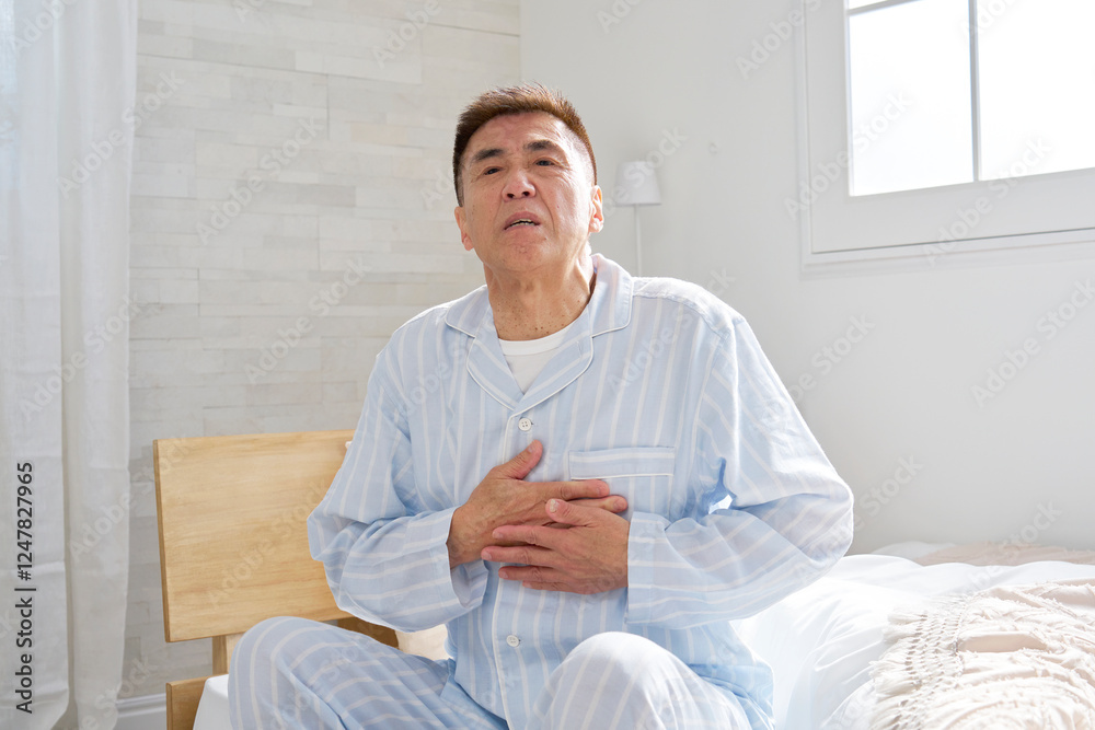 胸が痛いパジャマを着た中年の男性 胸が痛いパジャマを着た中年の男性