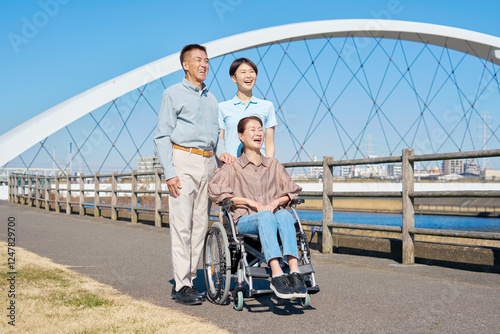 夫と車椅子に乗った妻と介護士　屋外　ポートレート photo