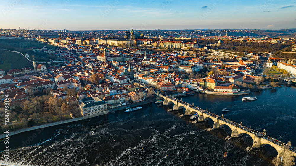 Obraz premium Prague, Czech Republic - Aerial panoramic drone view of the world famous Charles Bridge (Karluv most) and St. Francis Of Assisi Church with a beautiful winter sunset. St. Vitus Cathedral at background