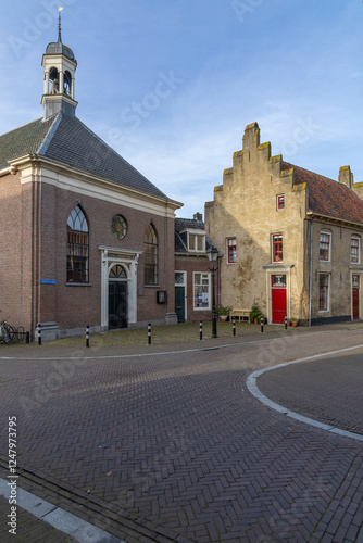 The Pietersgasthuis (a remnant of the original building) is one of the oldest buildings in Culemborg, looking into the street with a brick street and pavement. photo