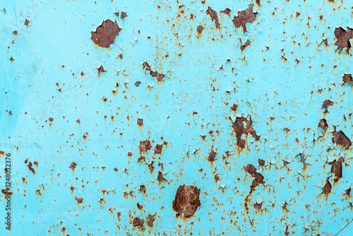 A close-up of a weathered metal surface with peeling blue paint and rust patches. The texture highlights the natural process of aging and corrosion, creating an abstract, organic pattern of decay 