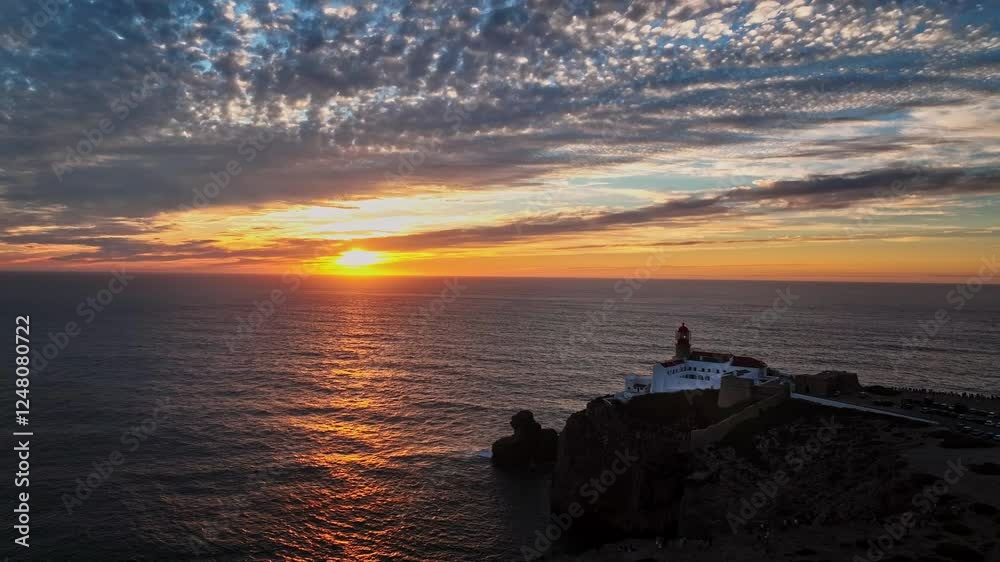 Aerial shot capturing the lighthouse against the vast open sea at sunset. Aerial shot capturing the lighthouse against the vast open sea at sunset.