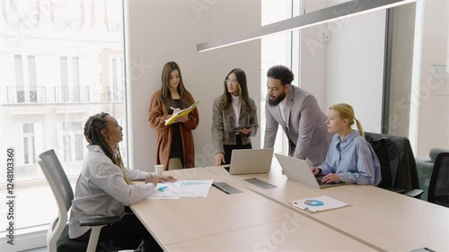 A diverse and talented group of professionals is seen collaborating in a modern office setting, showcasing effective teamwork and fostering innovation within a vibrant and dynamic work environment