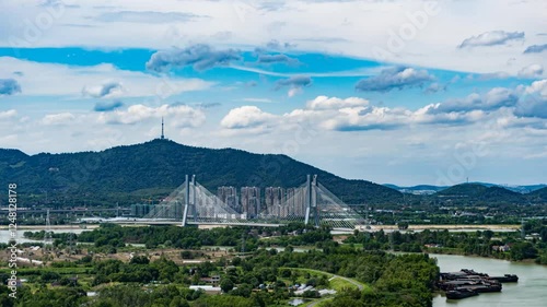 Exploring picturesque mountains and bridges under a bright blue sky with rolling white clouds in a serene time lapse