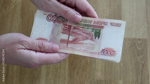 The currency of Russia. Close-up of Russian rubles. Financial concept. The background and texture of banknotes. The woman's hands count the 5000 rubles banknotes