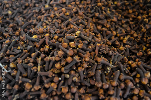 Close-up of dried cloves showing their dark brown color and textured surface. The image highlights the details of dried clove buds, commonly used as a spice for cooking, herbal remedies, and aromatics